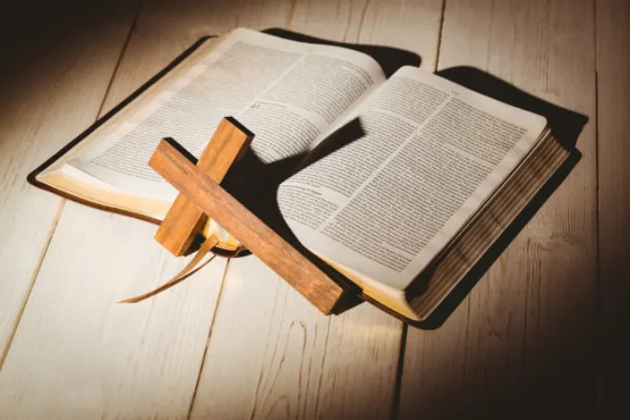 An open Bible with a wooden cross