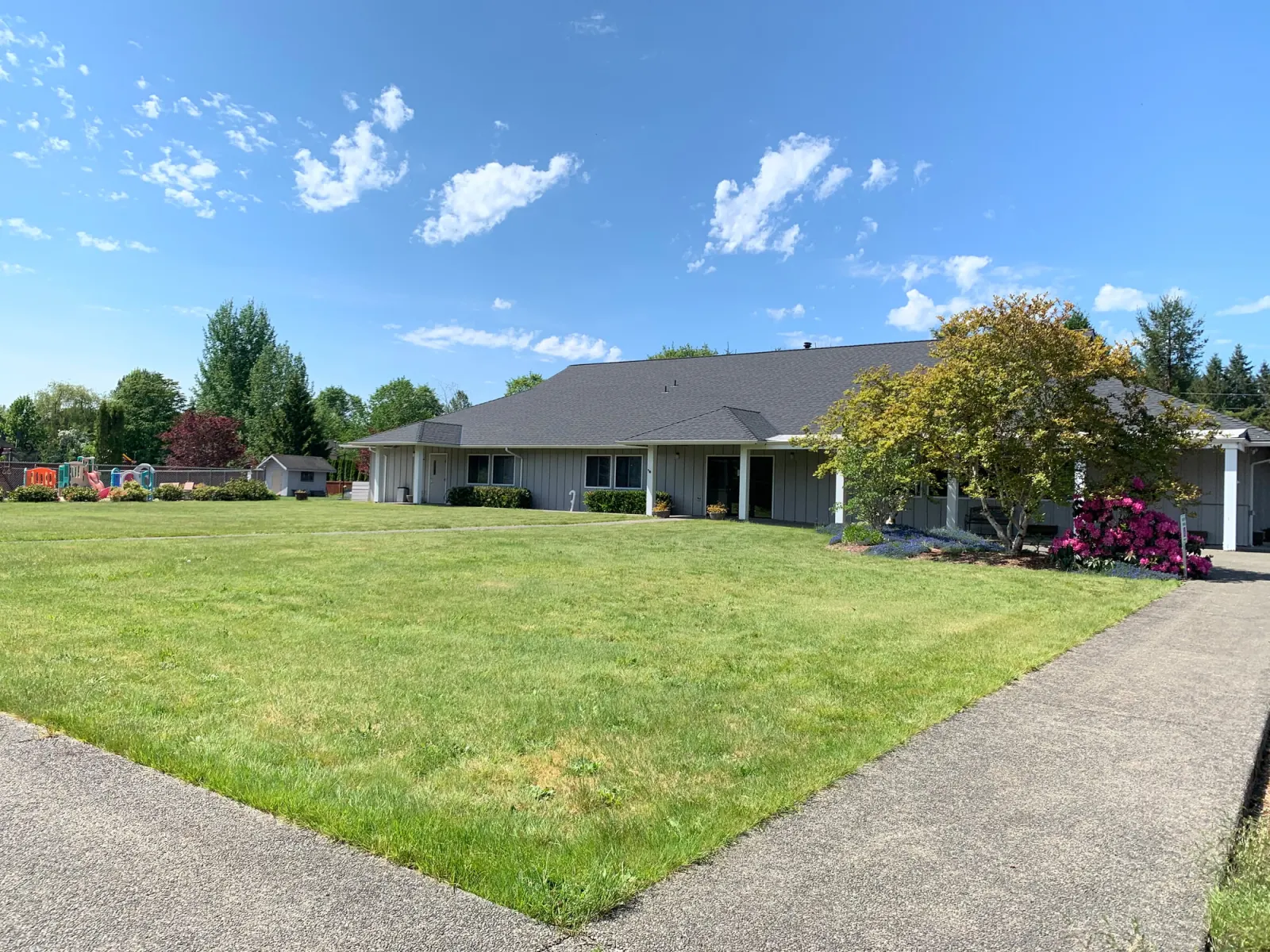 The Snoqualmie Valley Bible Church building in Carnation, with its lawn, trees and playground